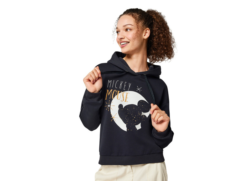 Une femme porte un sweat-shirt noir avec un motif Mickey Mouse.