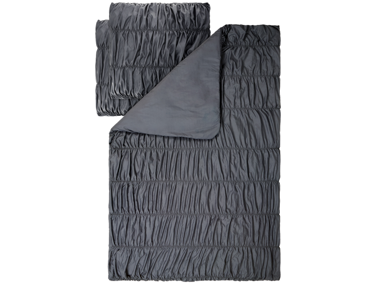 Parure de lit gris foncé avec housse de couette et taies d'oreiller plissées.