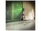 Un niveau laser vert sur un trépied dans une zone de construction.