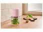 Hachoir rose avec basilic et huile, ingrédients pour pesto sur une planche à découper.
