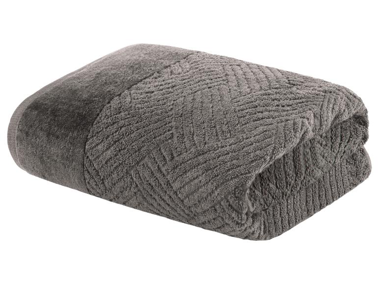 Une serviette de bain grise avec un motif en zigzag.