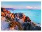 Des rochers sur la côte avec une eau turquoise en arrière-plan.