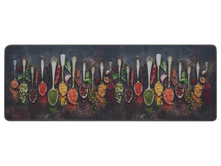 Tapis de cuisine avec cuillères remplies d'épices colorées et d'herbes sur fond sombre.