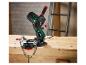 Affûteur de chaîne électrique sur un établi en bois dans un atelier.