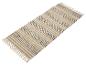 Un tapis beige et gris foncé à rayures avec des franges.