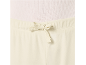 Détail d'un haut et d'un pantalon crème avec cordon de serrage.