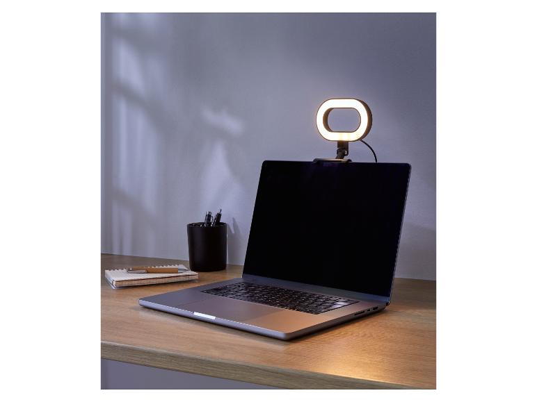 Un ordinateur portable avec une lumière annulaire sur un bureau.