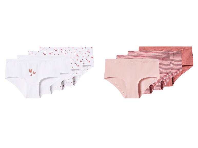 Deux paquets de culottes pour filles : l'un avec des motifs blancs et cœurs, l'autre rose et rayé.