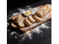 Baguette fraîchement cuite tranchée sur une planche en bois avec du beurre.