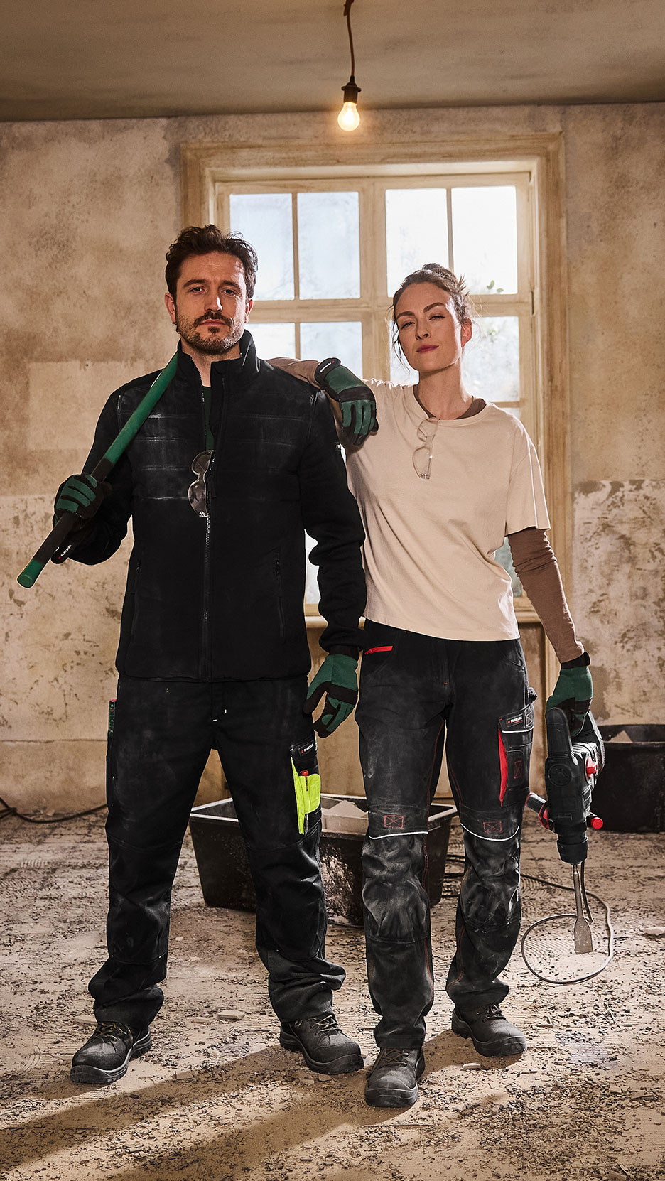 Deux personnes en vêtements de travail et chaussures de sécurité, avec des outils de construction.