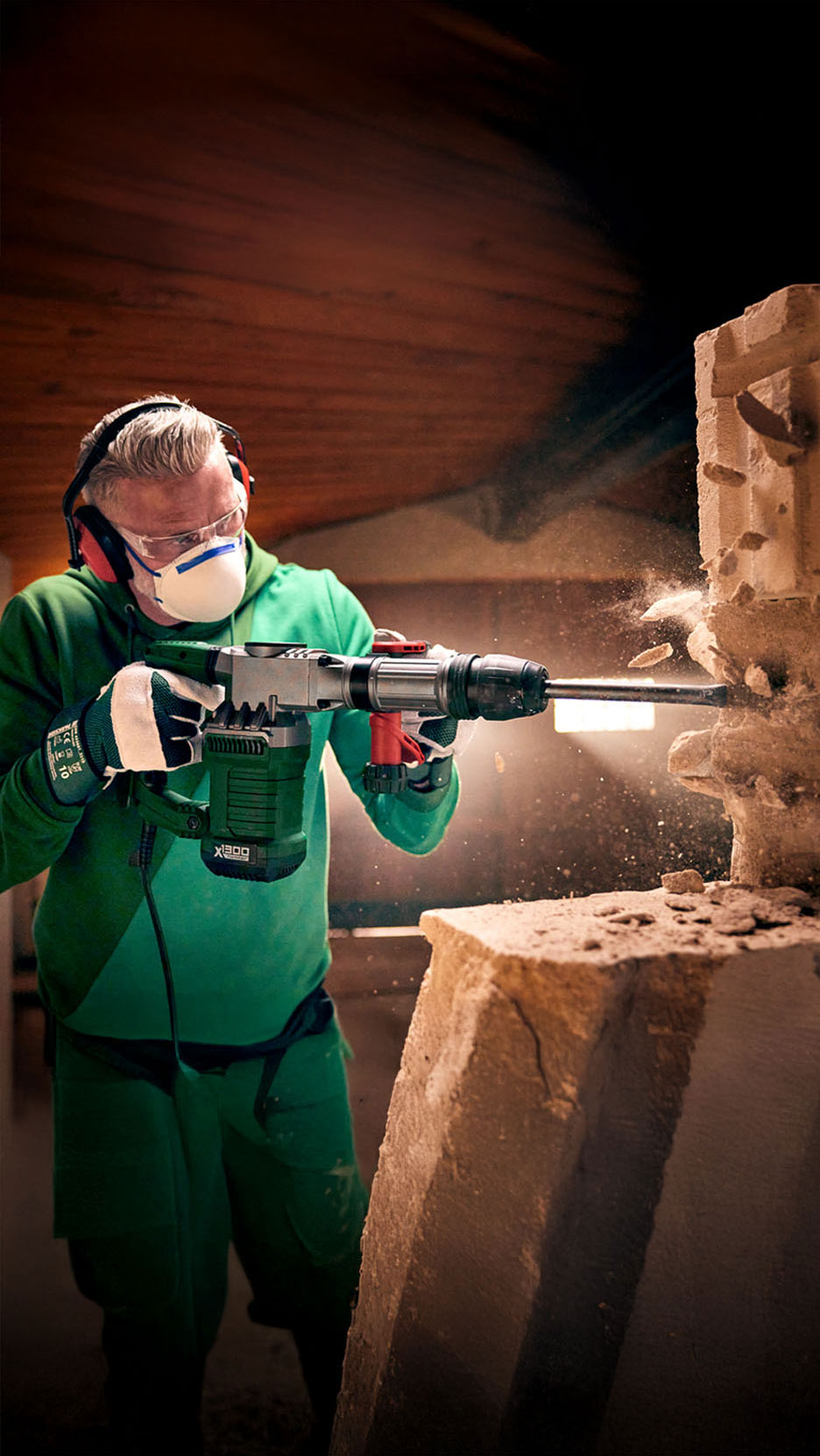 Un ouvrier démolit un mur avec un Einhell X-Hammer 1800.