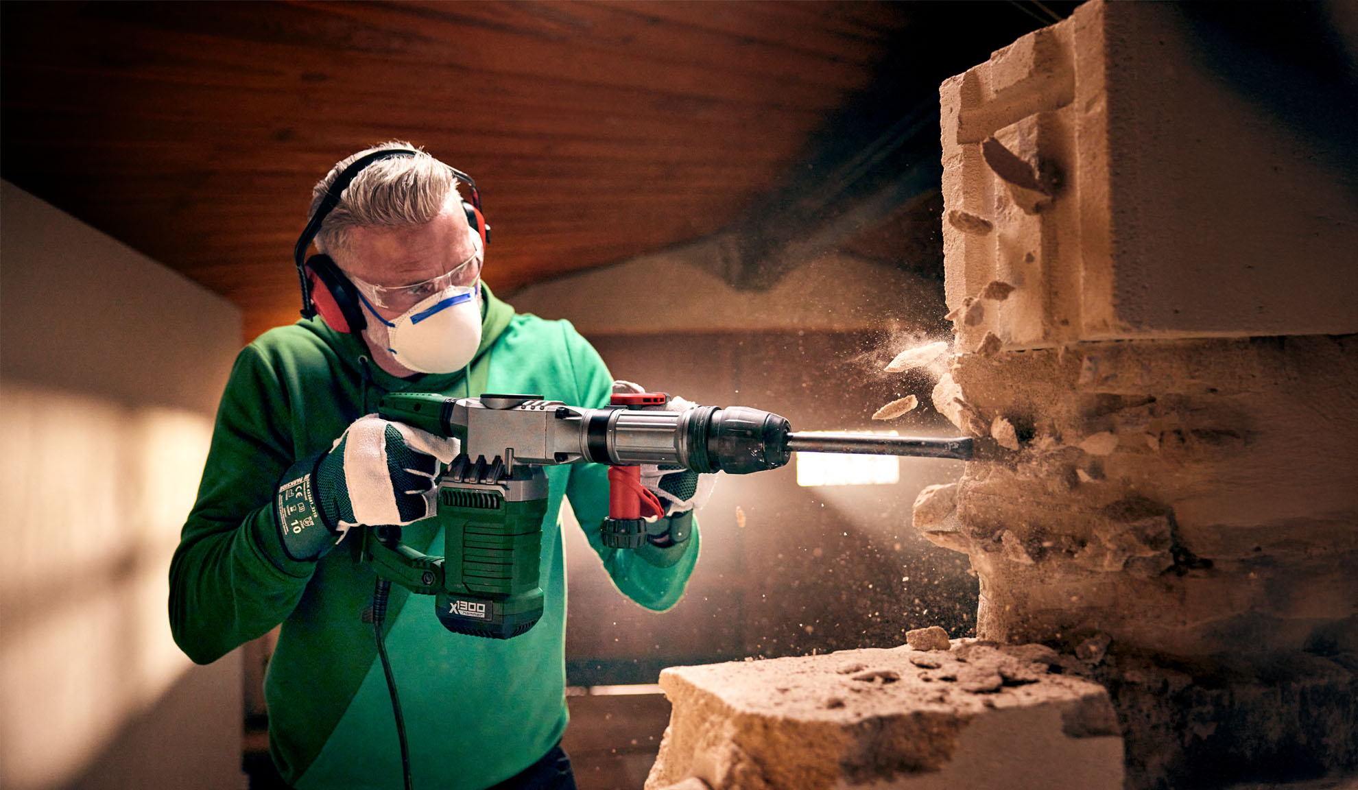 Un homme utilise un marteau démolition Worx X-BRUSHLESS pour casser un bloc de béton.