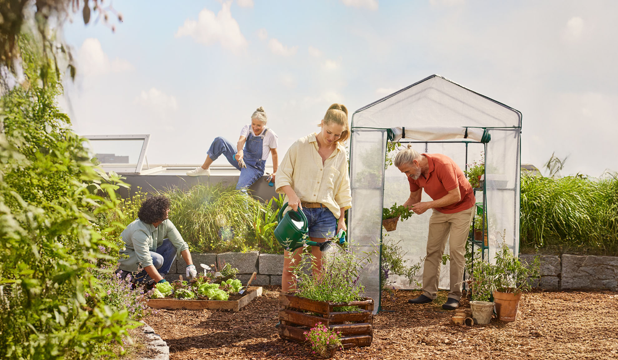 Un groupe de personnes cultive joyeusement un jardin sur le toit, utilisant une serre de jardin.