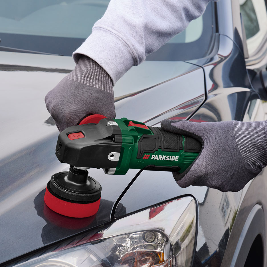 Une personne utilisant une polisseuse Parkside sur le capot d'une voiture.
