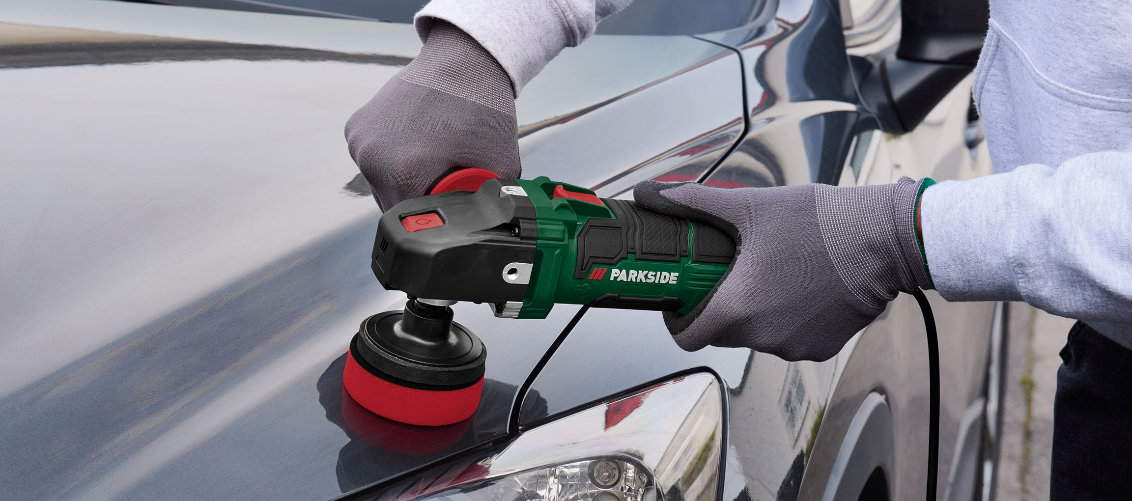 Une personne utilise une polisseuse Parkside pour polir une voiture.