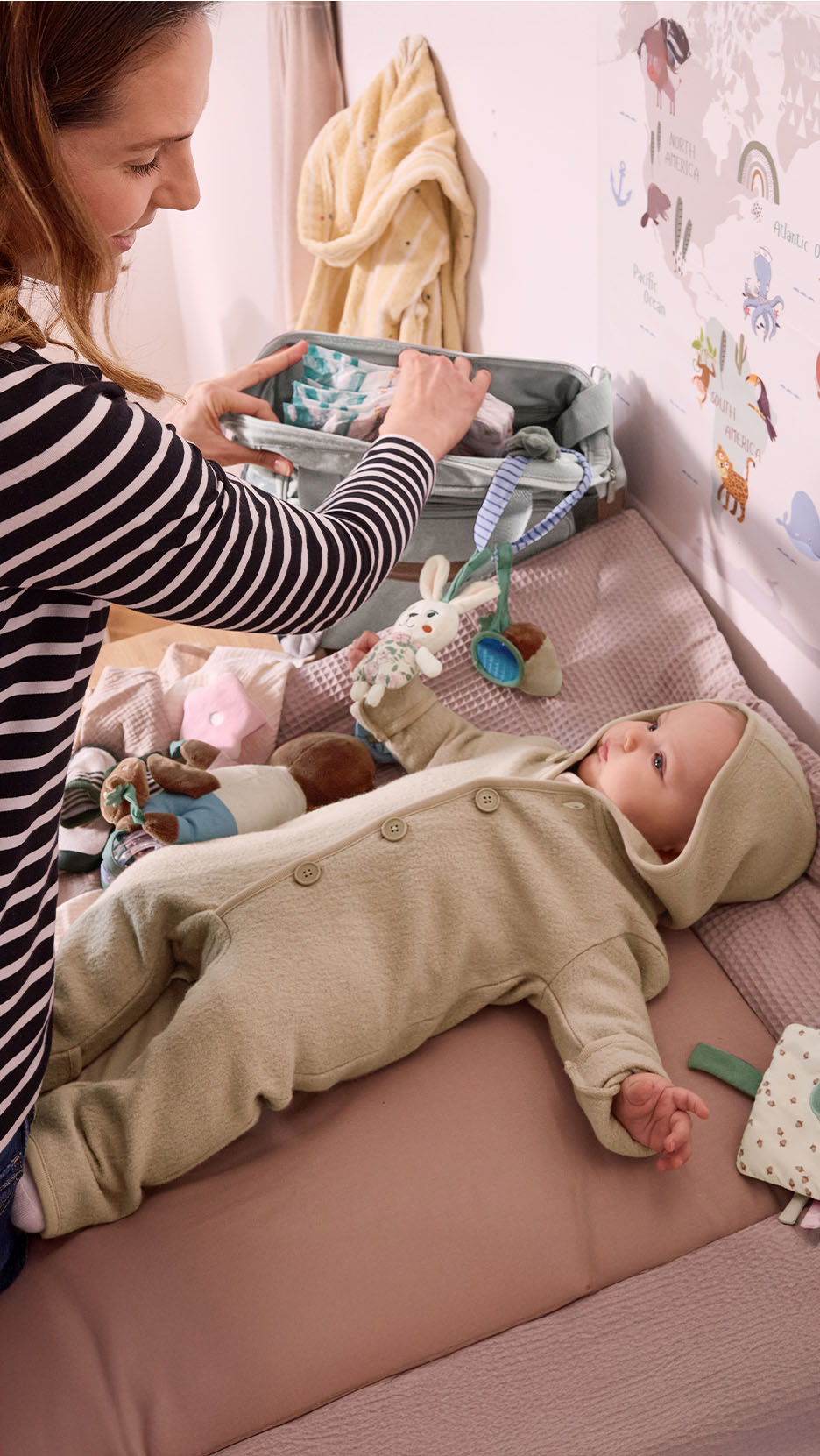 Mère organisant des couches et des produits pour bébé sur une table à langer.