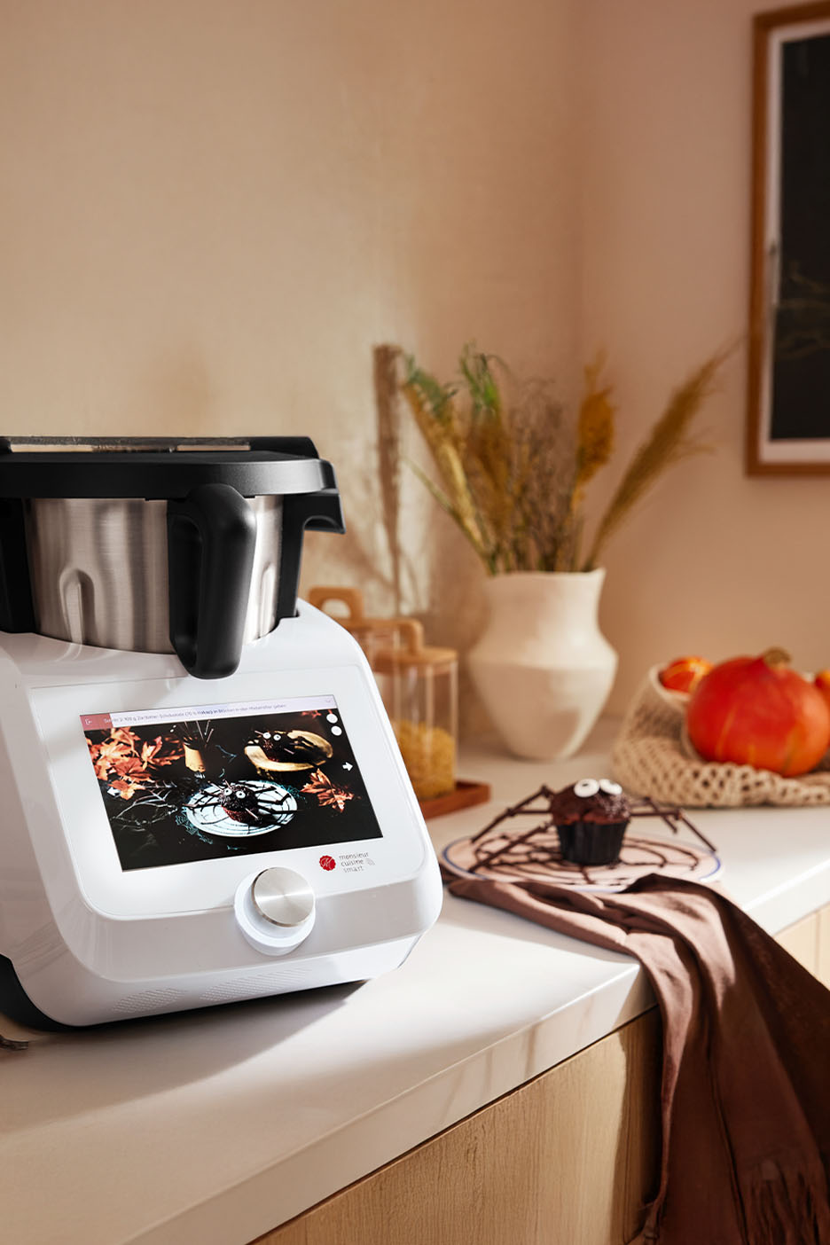 Robot de cuisine avec écran tactile, décoré pour Halloween, avec un cupcake araignée.