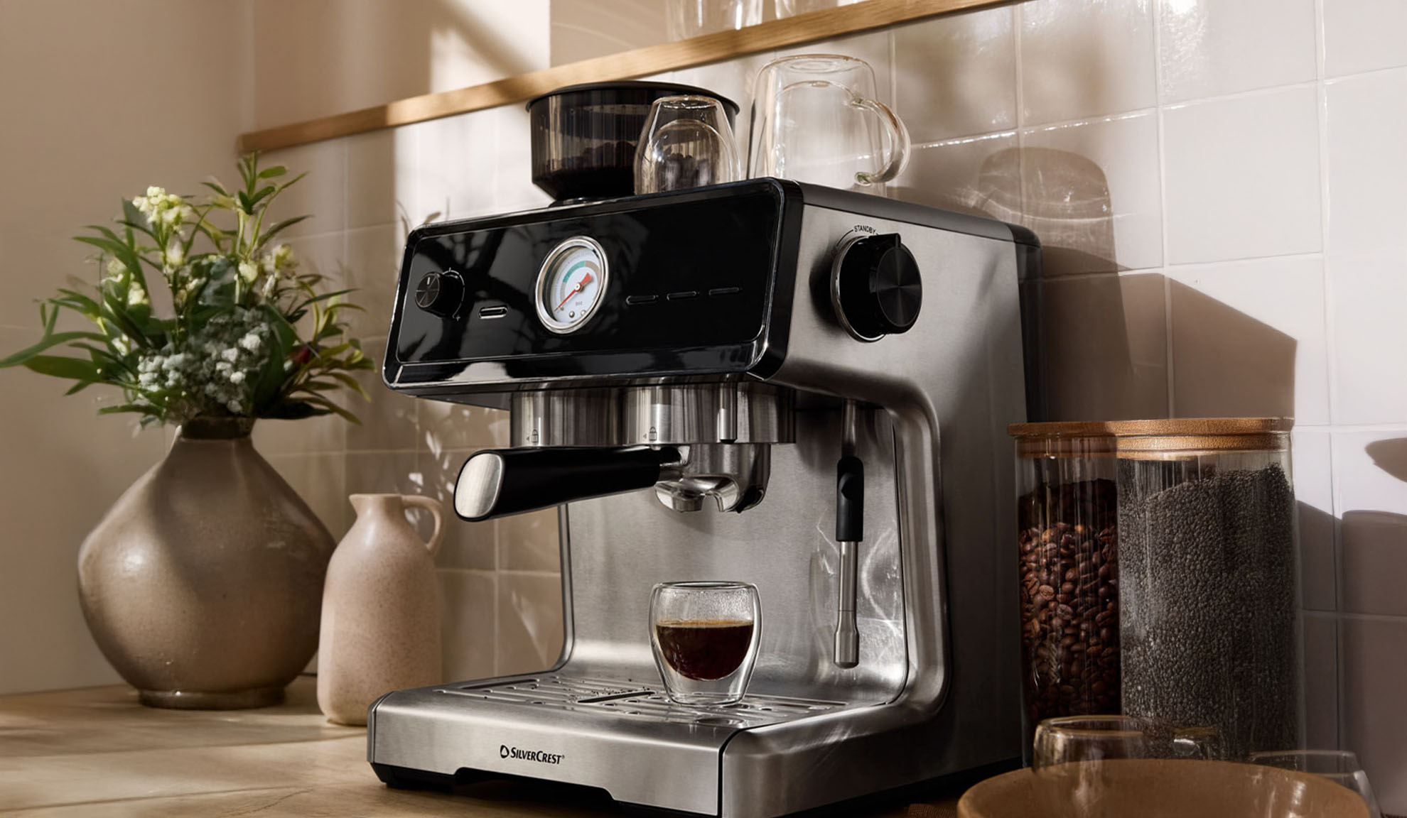 Machine à expresso SilverCrest sur un comptoir de cuisine avec grains de café et graines de chia.