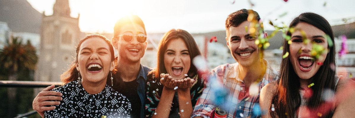Jeunes gens heureux célébrant avec des confettis.