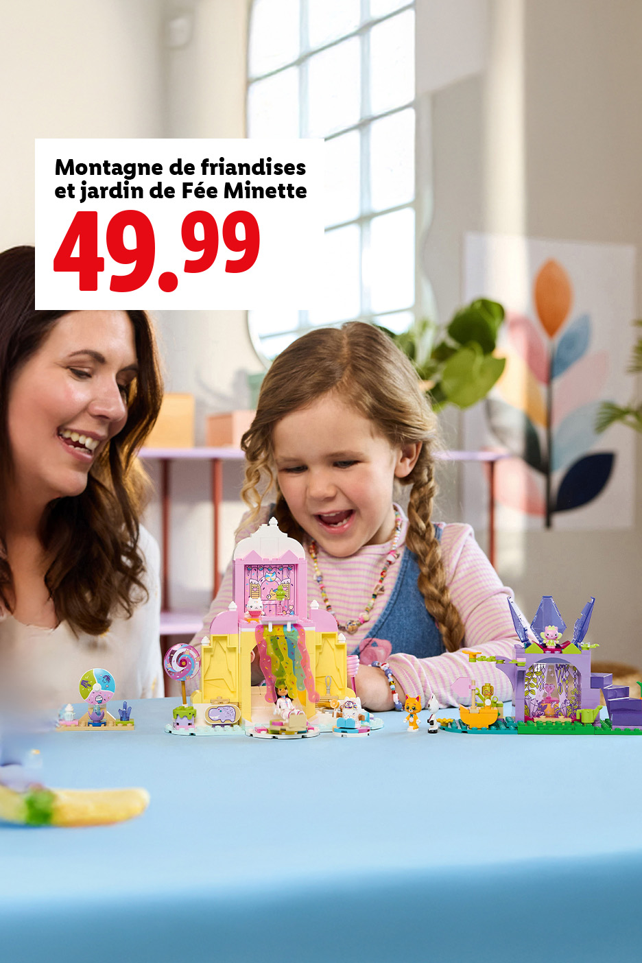 Une femme et une fille jouent avec des jouets de construction colorés sur une table bleue.
