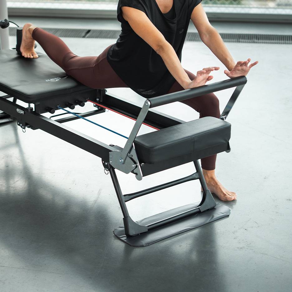 Femme faisant de l'exercice sur une machine de Pilates en tenue de sport