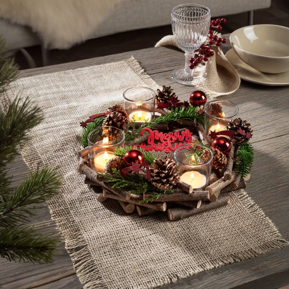 Décoration de table de Noël avec bougies, pommes de pin et branches de sapin sur un plateau en bois rustique et chemin de table en jute.
