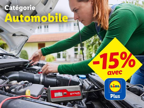 Une femme vérifie le moteur d'une voiture avec un chargeur de batterie, avec une réduction de 15%.