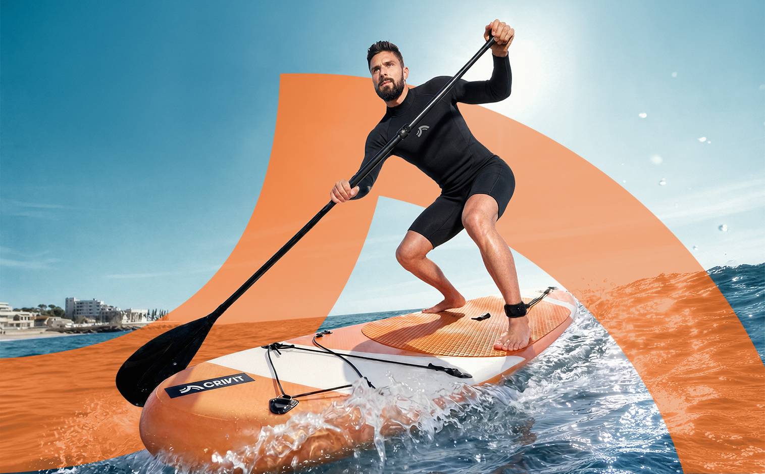 Homme en combinaison de plongée sur un paddle board orange et blanc, pagayant en mer.