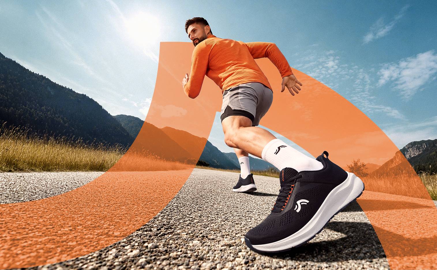 Homme en tenue de sport orange et grise, courant sur une route de montagne avec des chaussures de course noires.