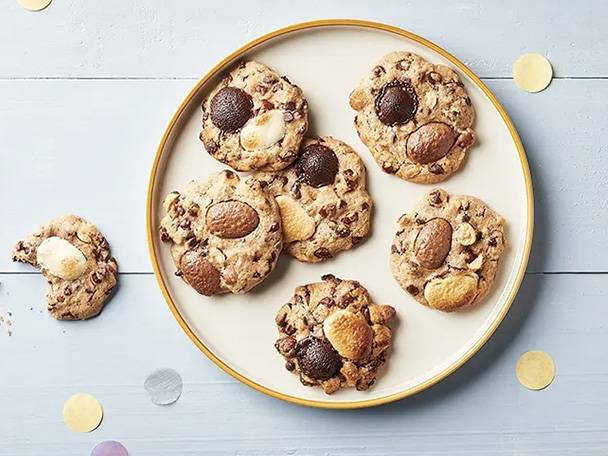 Cookies aux pépites de chocolat et aux noix sur une assiette, avec des confettis.