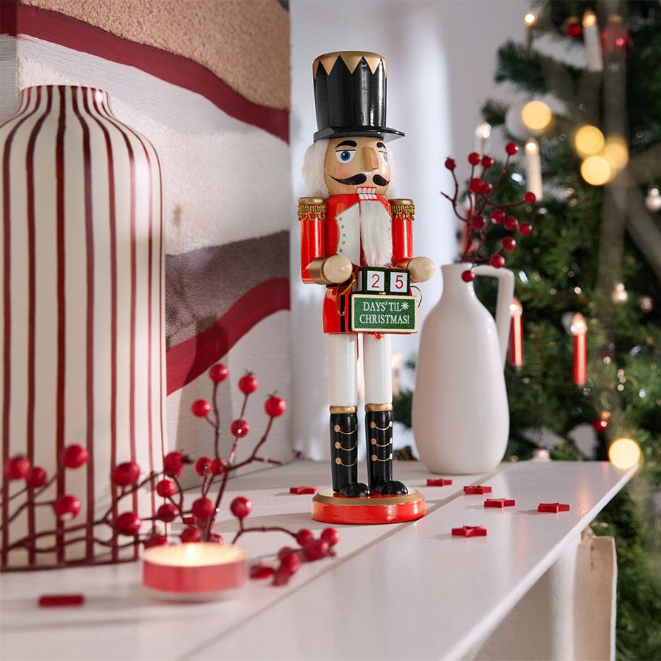 Casse-noisette avec calendrier de l'avent, vases et décorations de Noël sur une étagère.