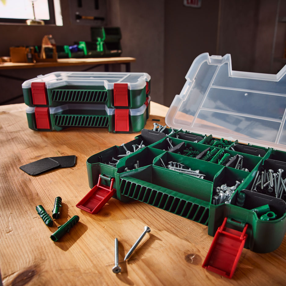 Organisateurs d'outils verts avec vis et chevilles sur un établi en bois.