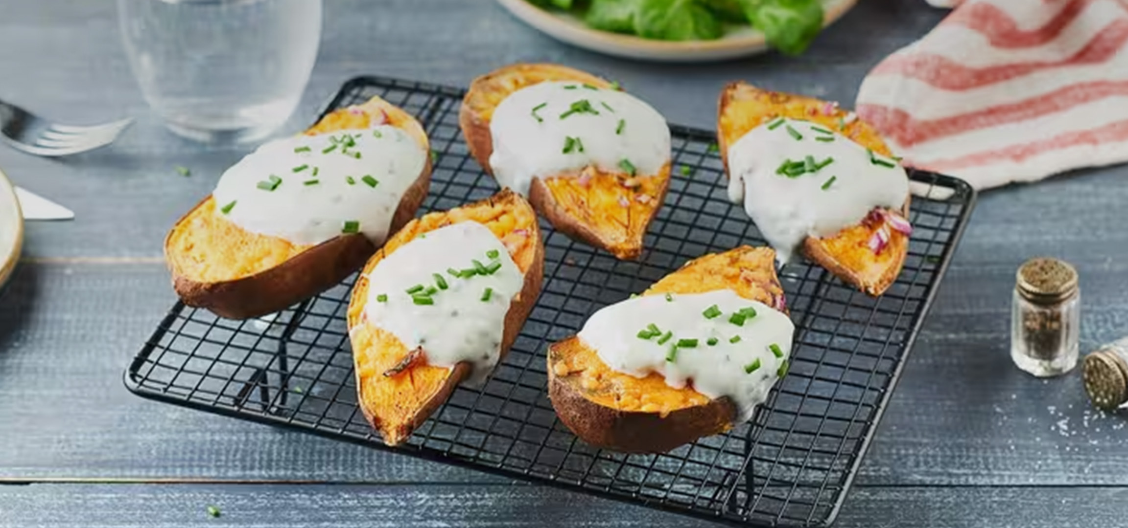 Pommes de terre farcies avec crème fraîche et ciboulette sur une grille de refroidissement.