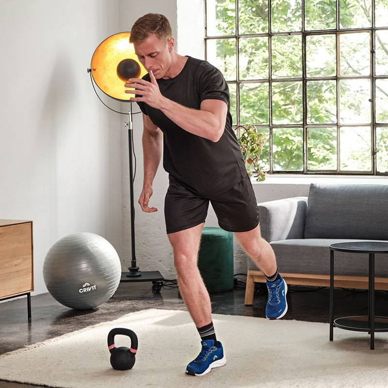 Un homme s'entraîne avec un medicine-ball Crivit, un kettlebell et une balle de gymnastique