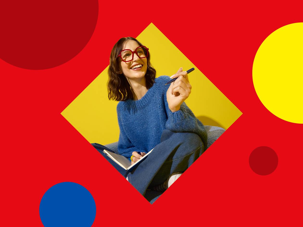 Femme souriante avec des lunettes rouges, un pull bleu et un carnet, sur fond géométrique.