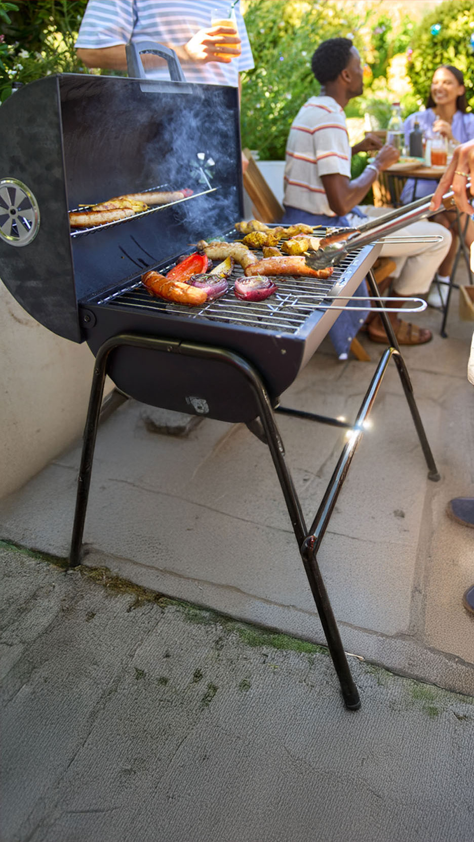 Un barbecue au charbon de bois avec des saucisses et des légumes grillés.
