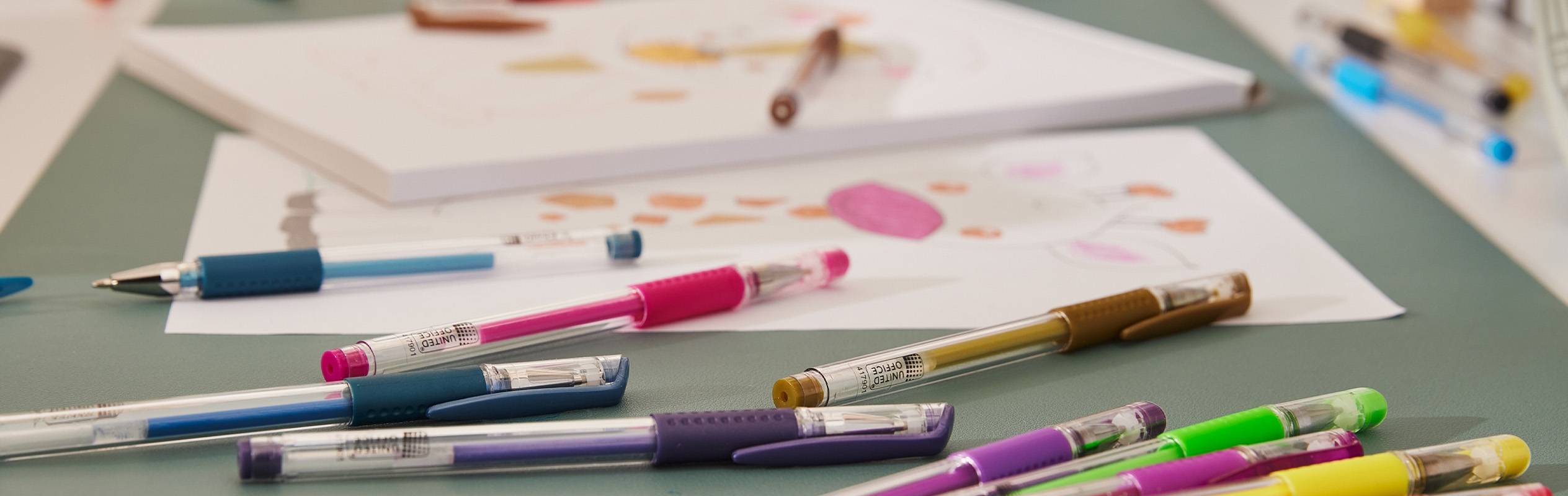 Des stylos gel colorés et des dessins d'enfants sur une table.