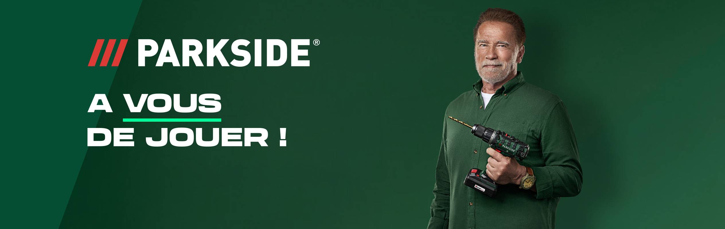 Arnold Schwarzenegger tenant une perceuse sans fil Parkside sur fond vert.