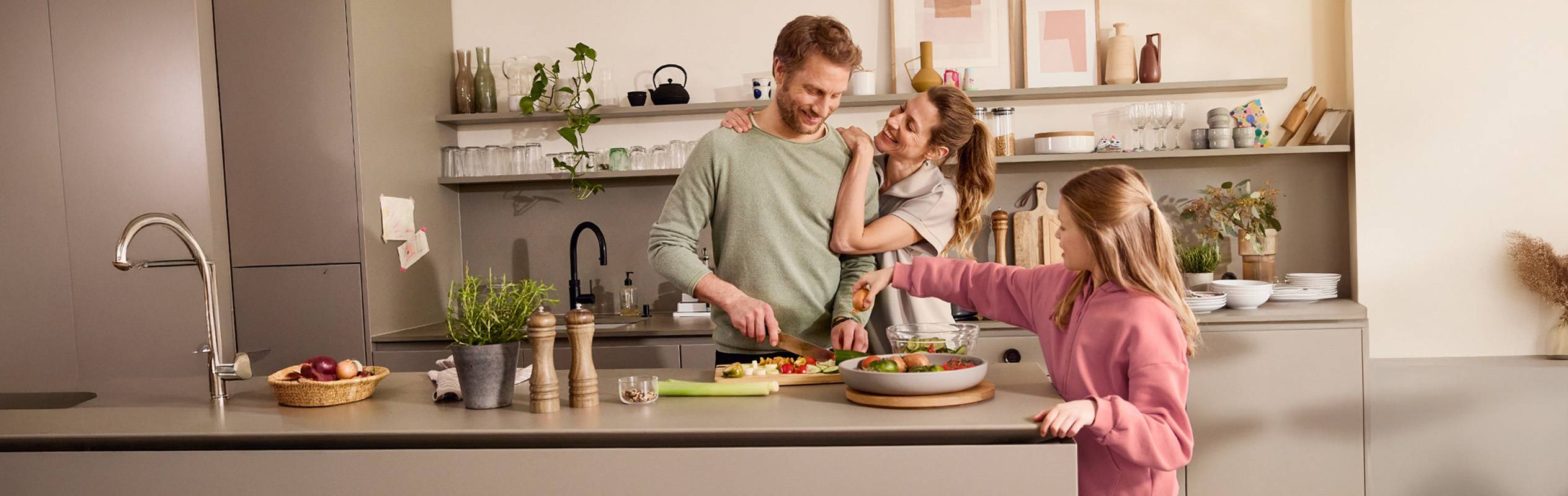 Une famille prépare un repas ensemble dans une cuisine moderne et élégante.
