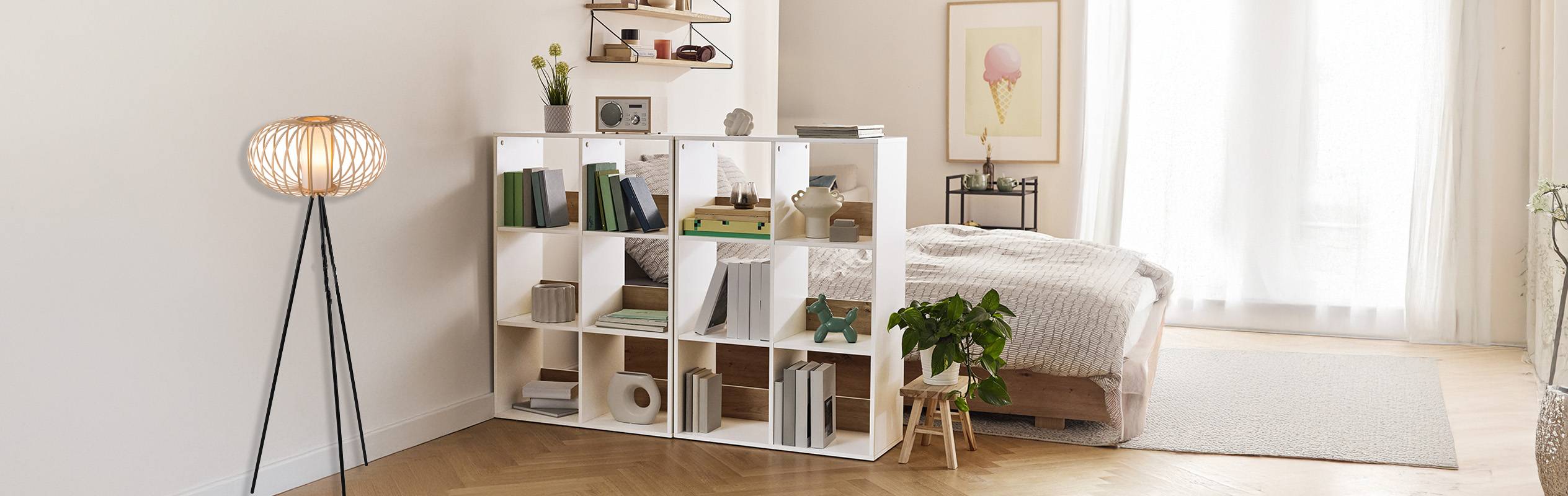 Un séparateur de pièce bibliothèque blanc et un lampadaire en rotin créent un espace de chambre à coucher stylé et organisé.