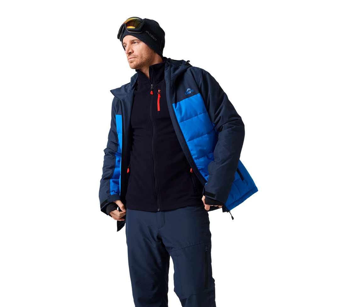 Homme en tenue de ski bleue et noire avec bonnet et masque.