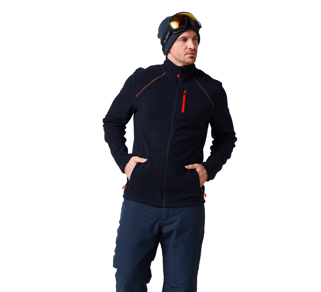 Homme portant une veste polaire de ski bleu marine, un bonnet et un masque de ski.