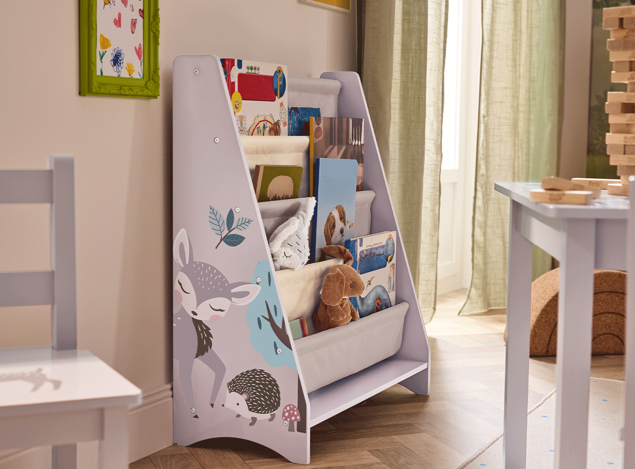 Étagère à livres pour enfants avec motif de forêt, livres et jouets en peluche dans une chambre d'enfant.