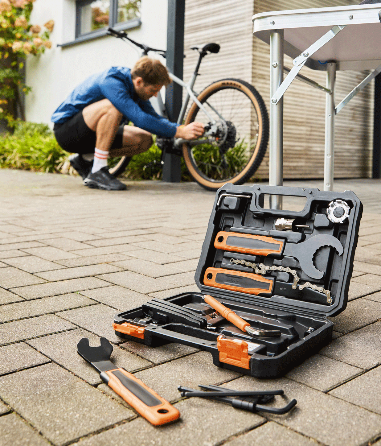 Trousse à outils de réparation de vélo avec un homme réparant un vélo en arrière-plan.