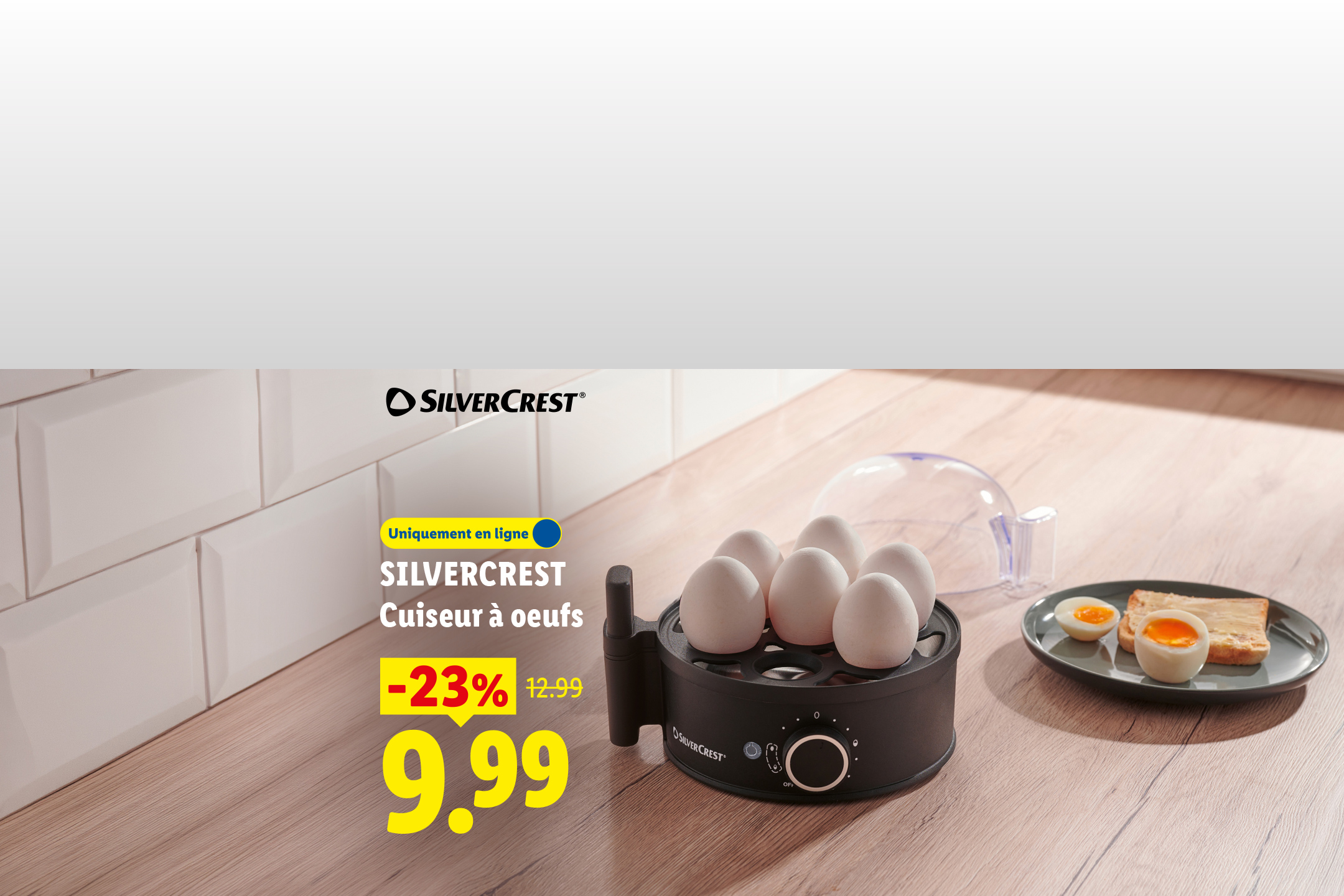 Un cuiseur à œufs noir avec six œufs, accompagné d'œufs à la coque et de toasts sur une assiette, avec une offre de -23% à 9,99€.