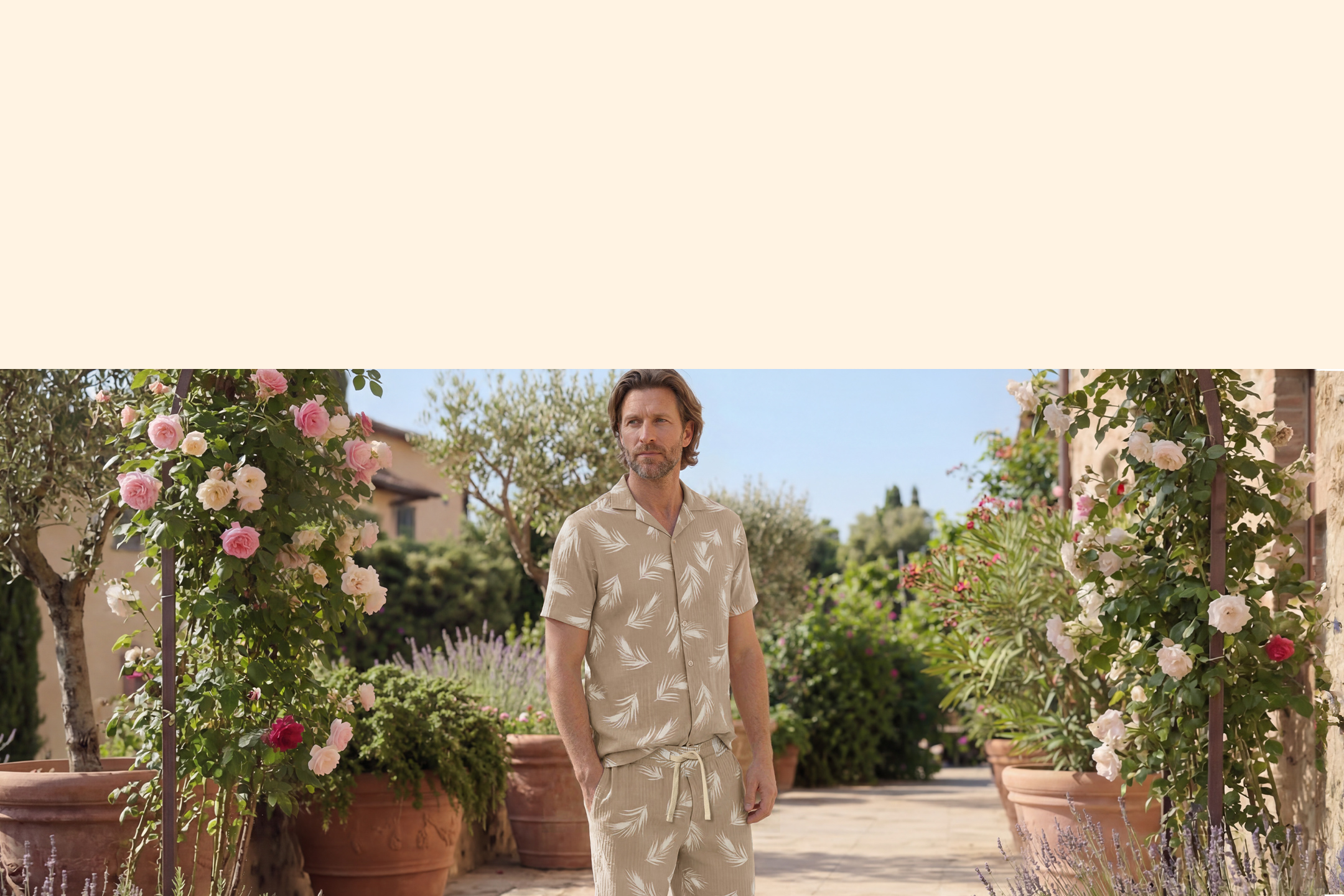 Homme en chemise et short à motifs de feuilles, dans un jardin fleuri.