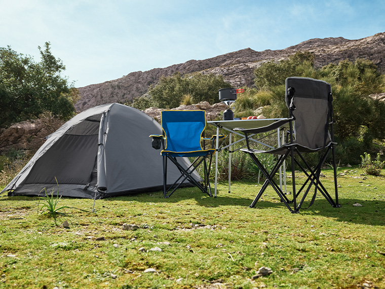 Un camping confortable avec tente, table pliante et chaises pliantes.