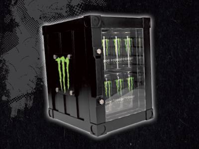 Un mini-réfrigérateur Monster Energy noir en forme de container, affichant des canettes à l'intérieur.