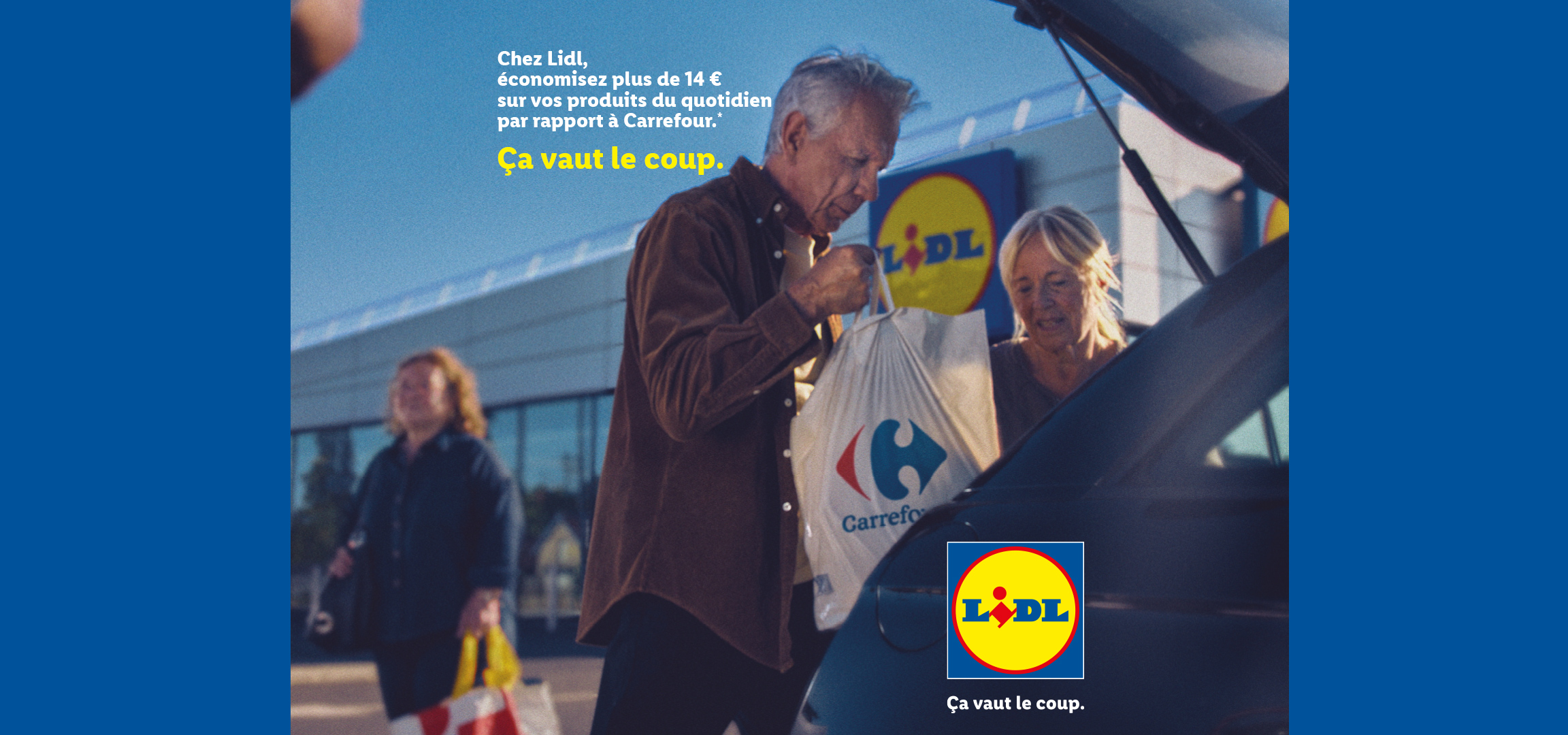 Un homme et une femme mettent des courses dans le coffre d'une voiture, avec le texte 'Chez nous, économisez plus de 14 € sur vos produits du quotidien par rapport à un concurrent. Ça vaut le coup.'