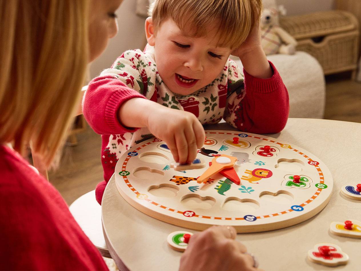 Enfant jouant avec un puzzle en bois éducatif représentant des animaux et des chiffres.